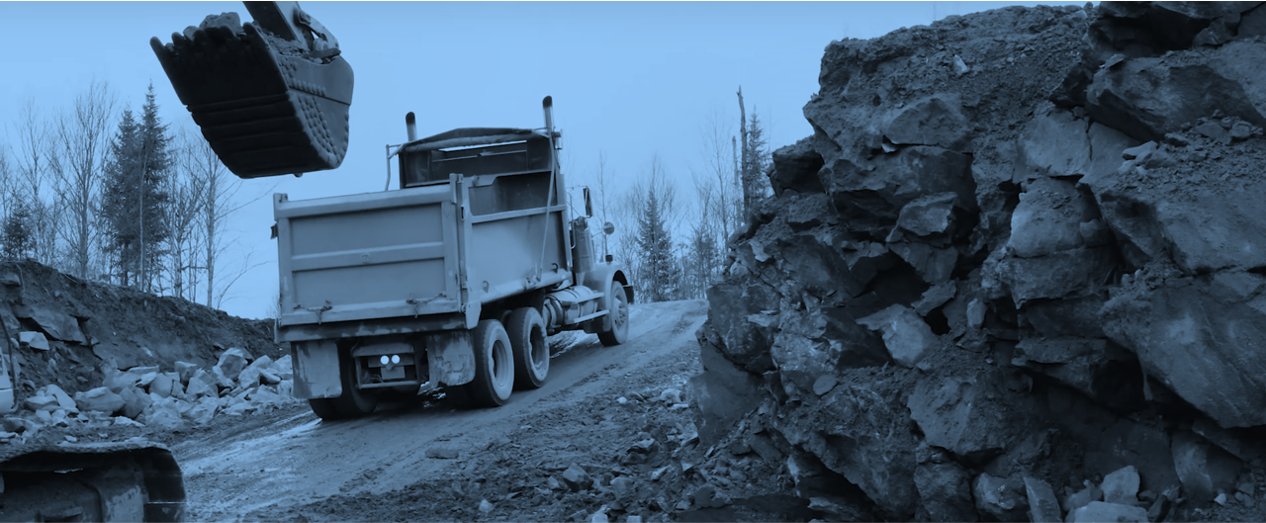 Excavator and truck on a mining site with blue filter